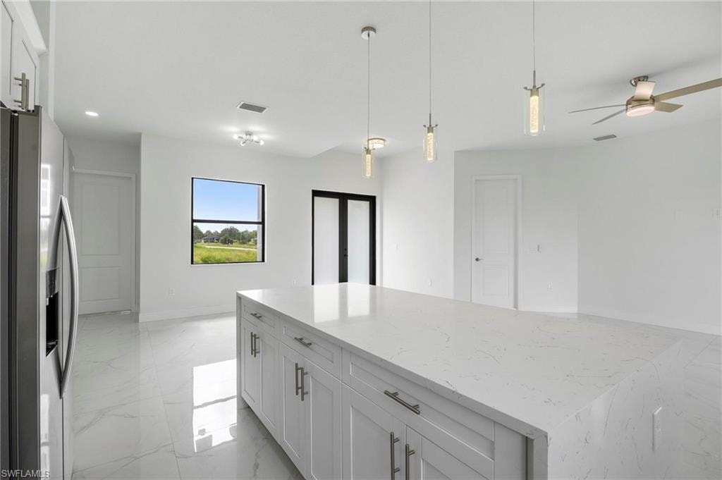 Kitchen island featuring a white countertop and base cabinetry with silver hardware