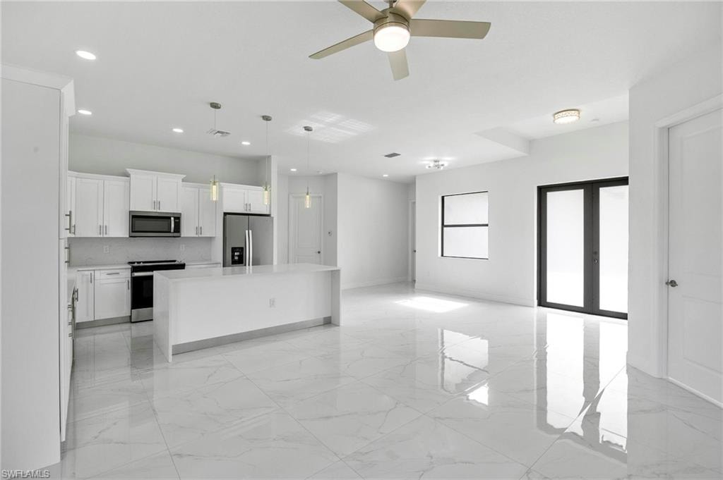 Open-concept living area featuring large format polished tile flooring and recessed lighting