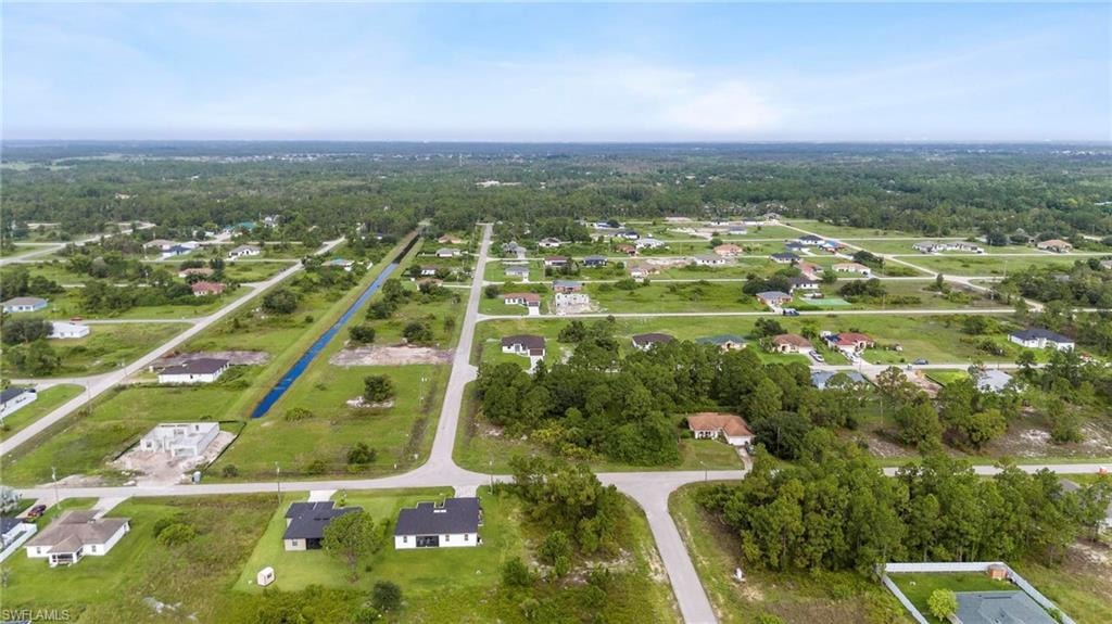 Aerial perspective of a residential area featuring single-story homes and undeveloped lots