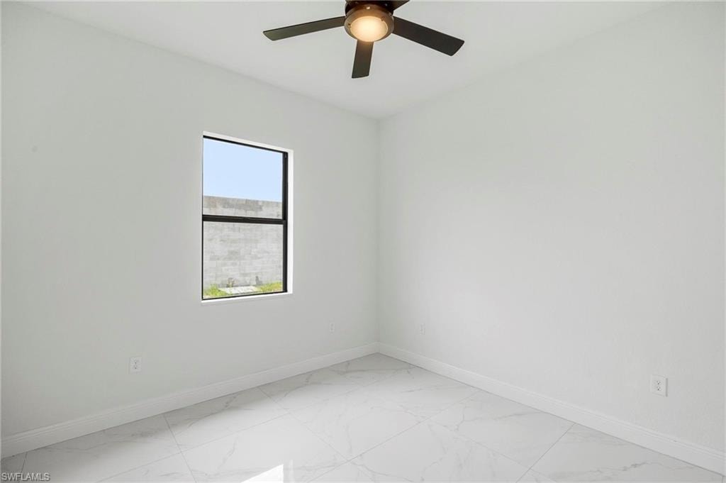 Bright interior space featuring large format tile flooring, a contemporary ceiling fan with integrated lighting, and a single window with black framing