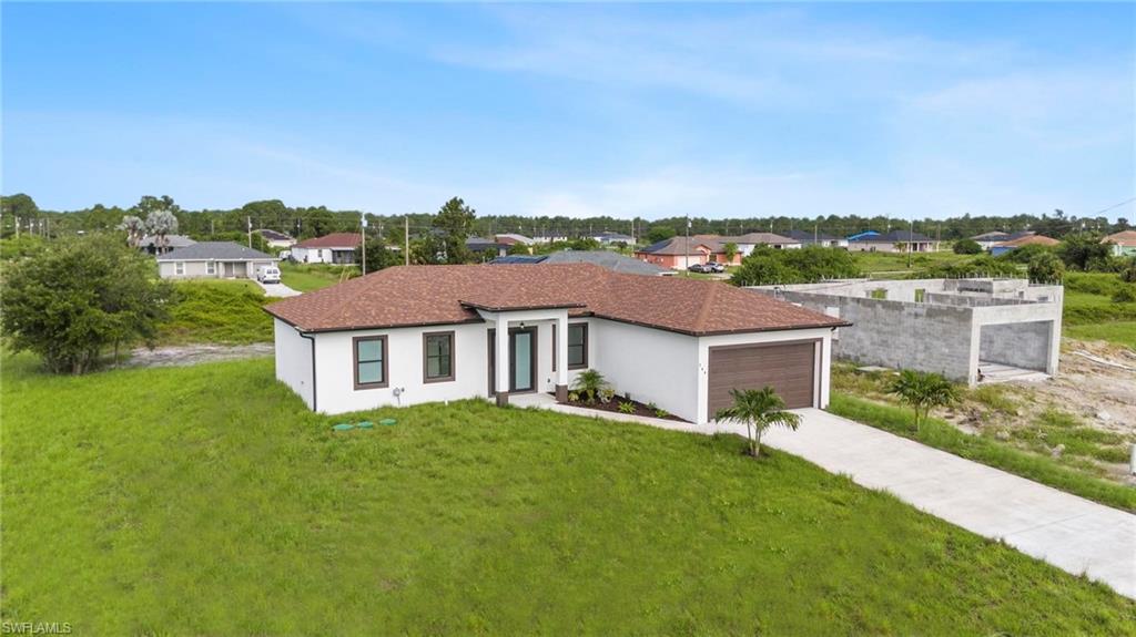 Contemporary single-story residence featuring a brown tile roof, crisp white exterior, dark-framed windows, and a wood-finish garage door