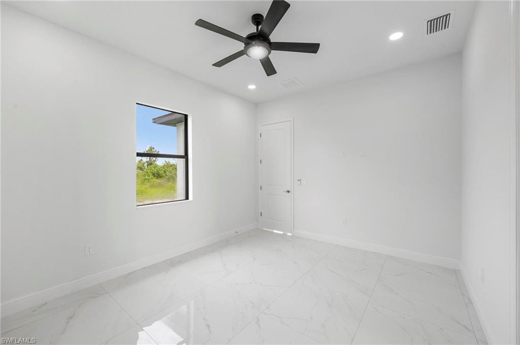Room featuring large format porcelain tile flooring, a modern black ceiling fan, recessed lighting, a single window, and a white interior door