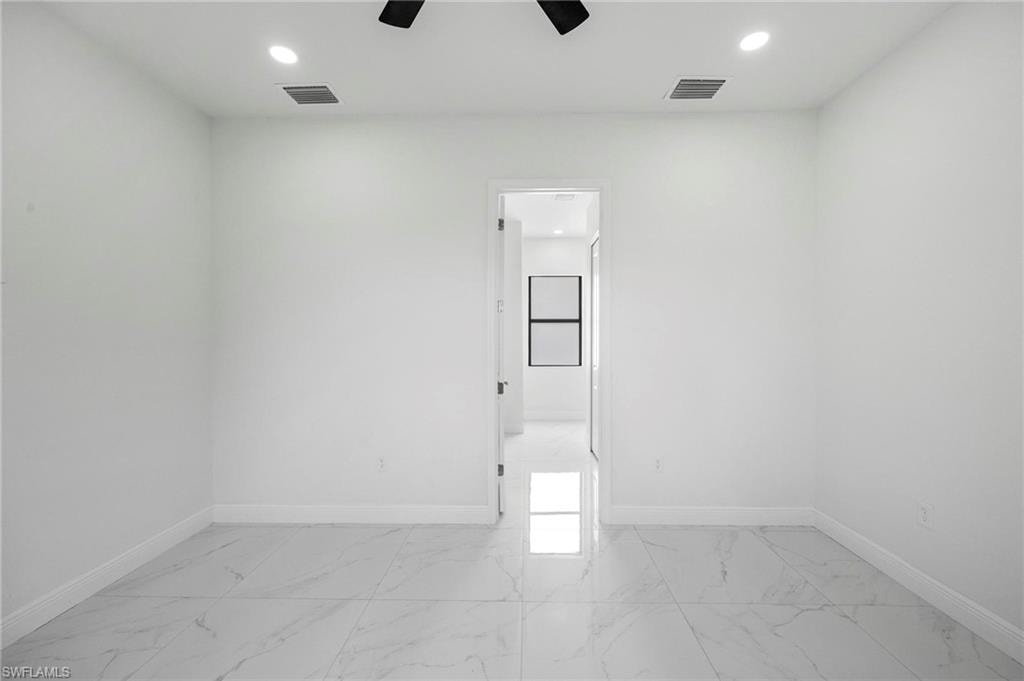 Spacious room featuring large format tile flooring, recessed lighting, and a white interior door