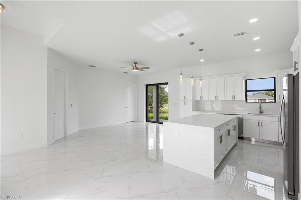 Open-concept living area featuring large format tile flooring and a ceiling fan
