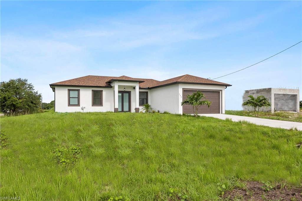 Modern white stucco exterior with a brown shingle roof