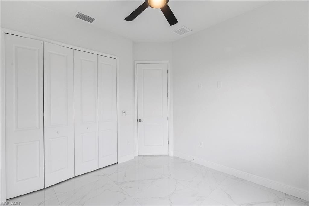 Bright interior space featuring white walls and a white-and-gray marble-finish floor