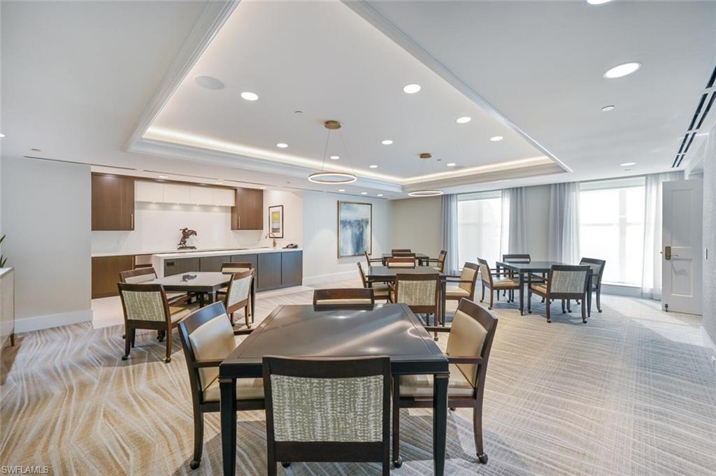 Spacious common area featuring patterned carpeting, recessed lighting, and a tray ceiling with accent lighting