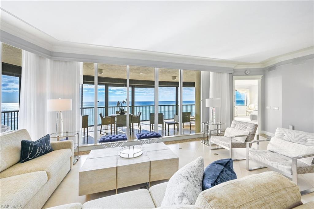 Expansive living area featuring floor-to-ceiling sliding glass doors, white tile flooring, and crown molding