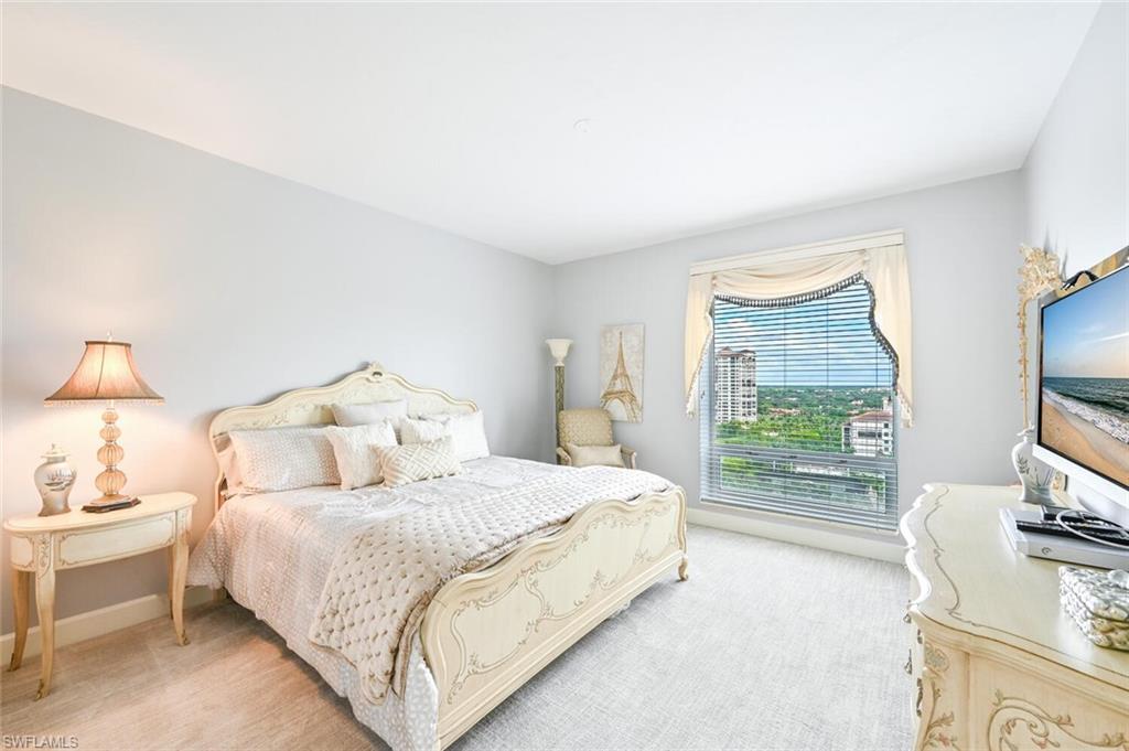 Spacious room featuring light gray walls and plush carpeting