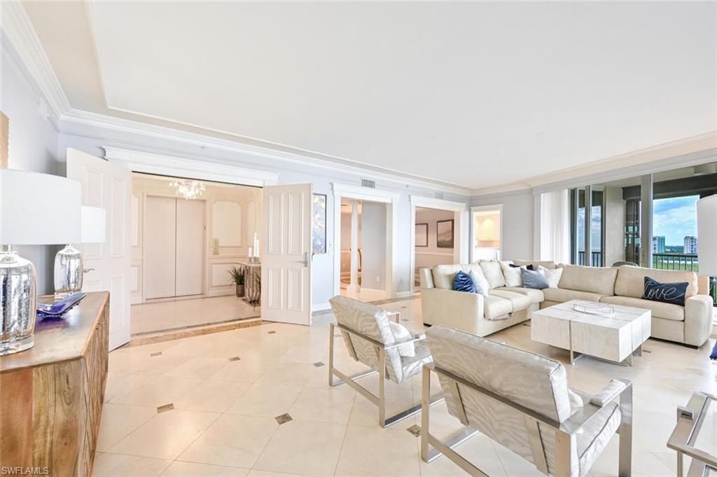 Expansive living area with neutral tile flooring featuring decorative inlays