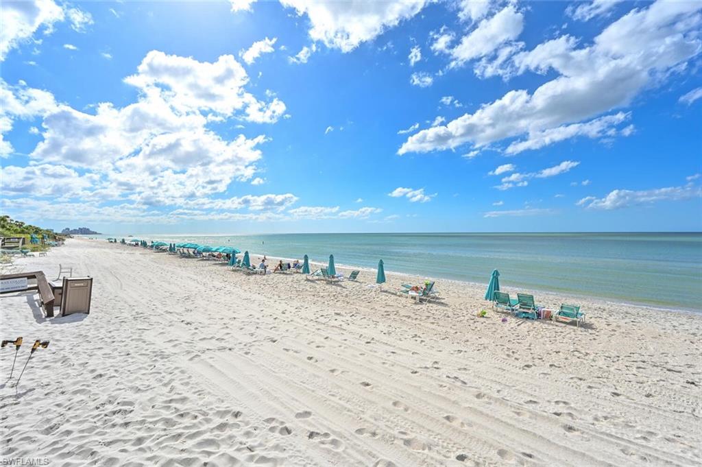 Expansive sandy beach with calm ocean waters extending to the horizon
