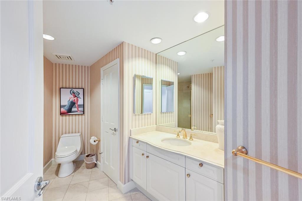 Bathroom featuring a vanity with a light-colored countertop, integrated sink, and gold-tone fixtures