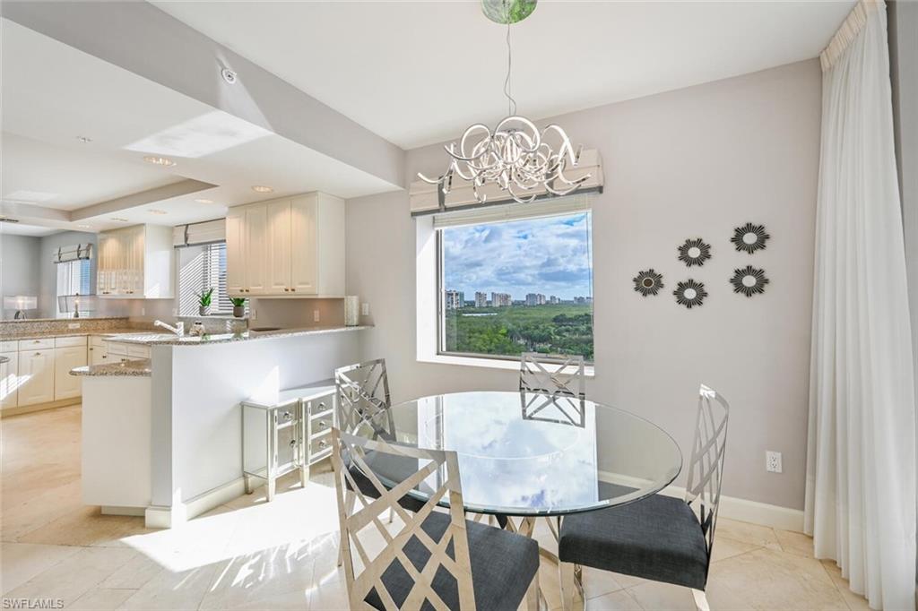 Open-concept living space featuring a window with city and natural area scenery, a contemporary chandelier, recessed lighting, and tile flooring