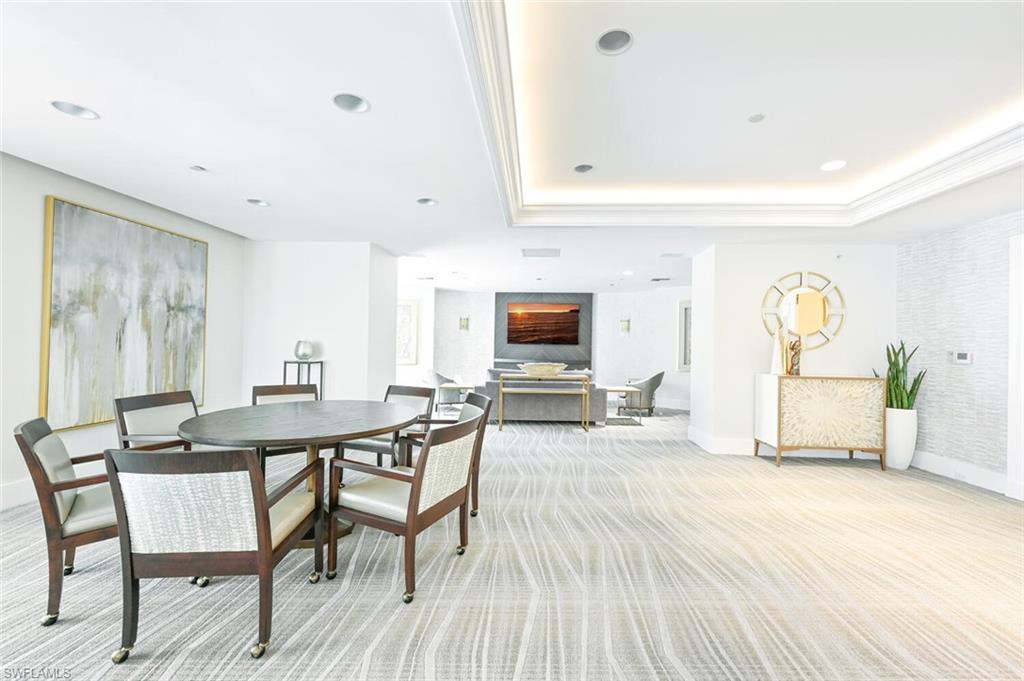 Spacious interior featuring cove lighting, recessed lighting, crown molding, patterned carpet flooring, and a built-in console table