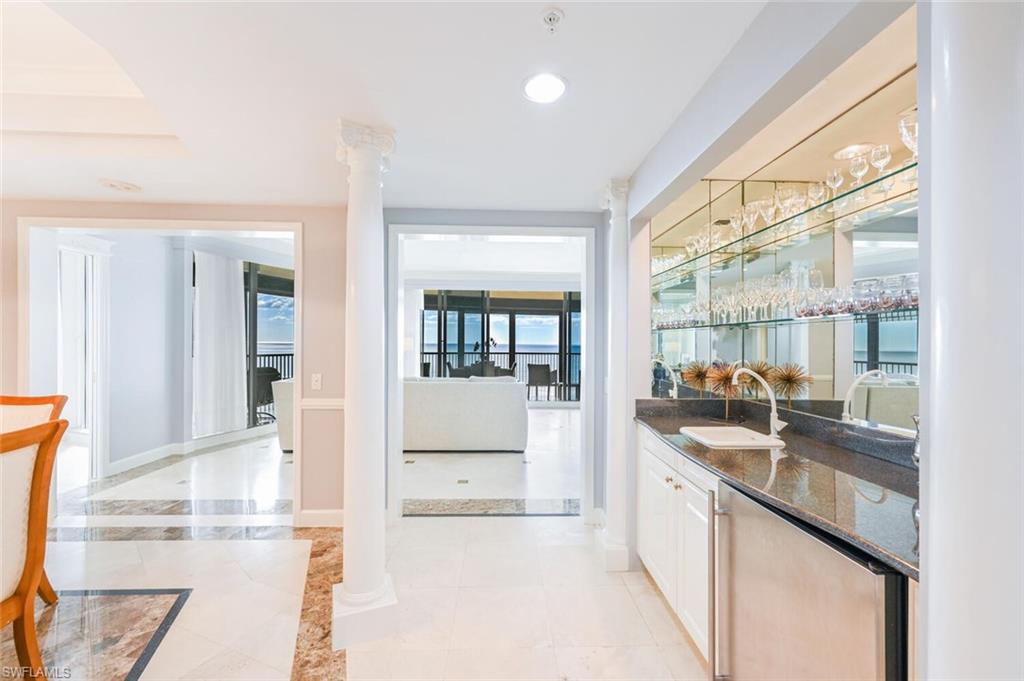 Wet bar with integrated sink, under-counter refrigerator, and mirrored shelving
