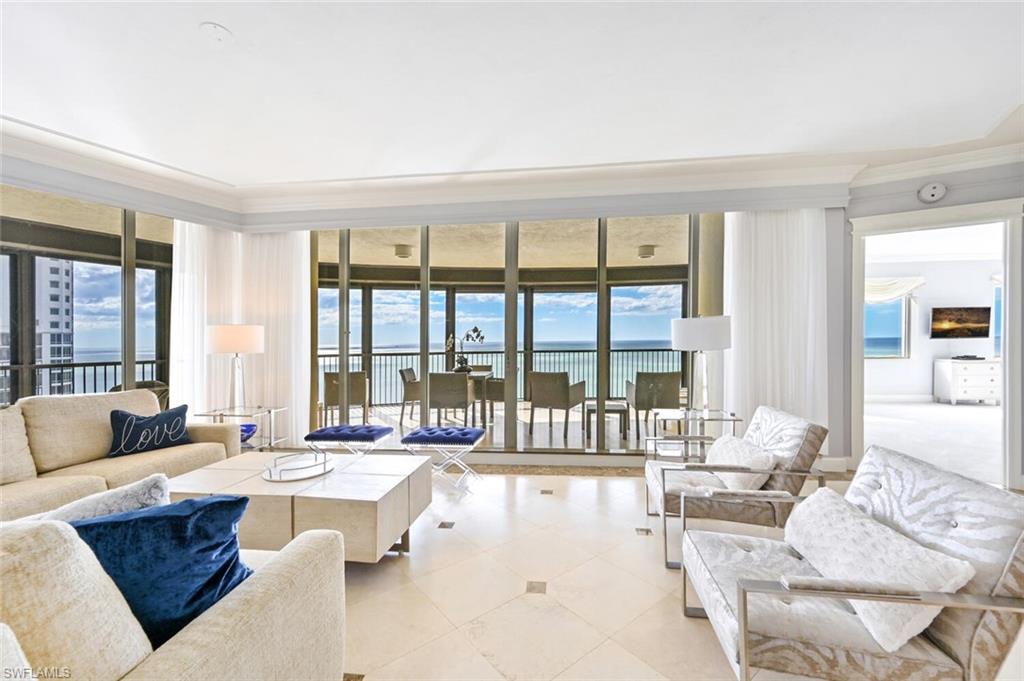 Expansive living area with large format tile flooring and crown molding