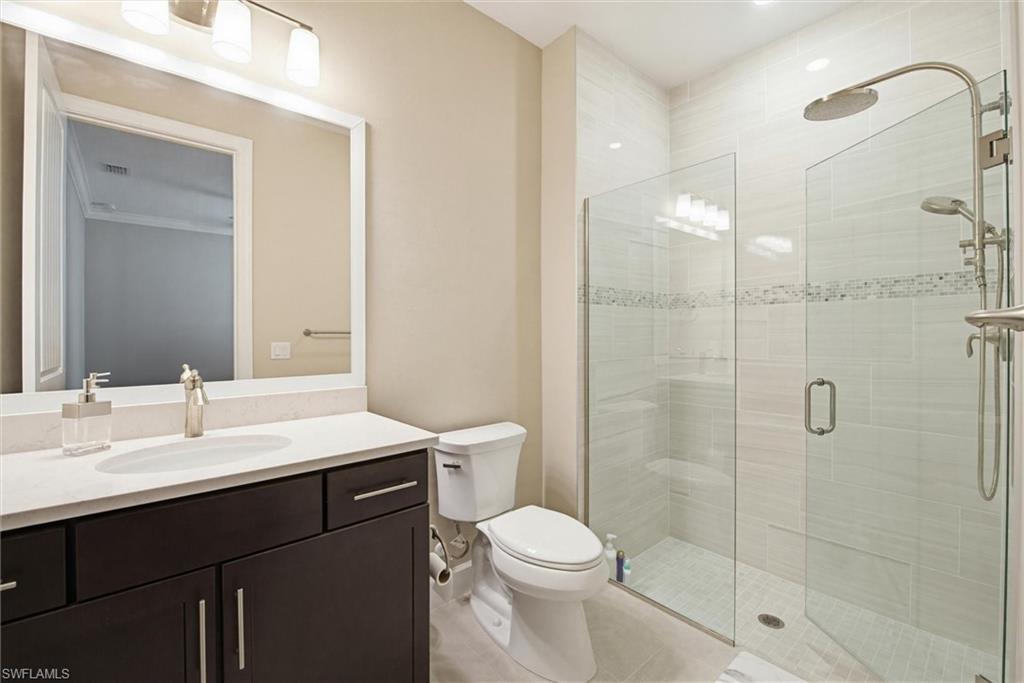 Full bath with a shower stall, vanity, and light tile patterned floors