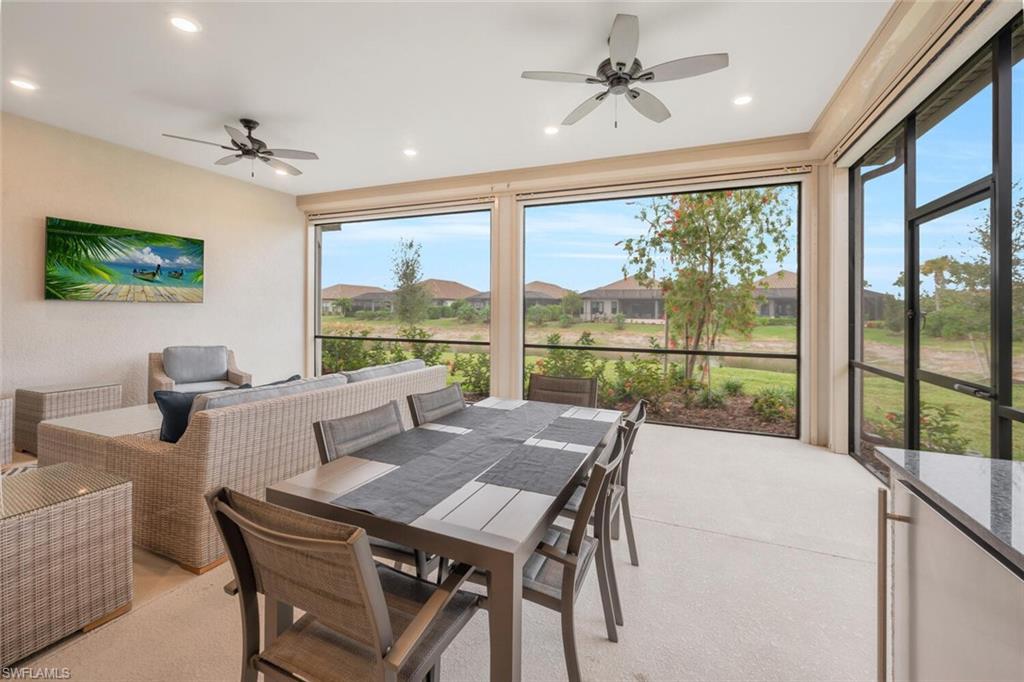 Screened outdoor living area featuring a light-colored floor, recessed lighting, and ceiling fans
