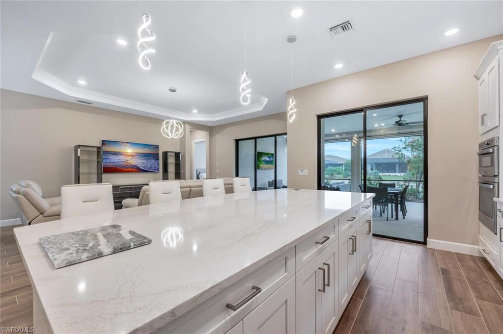 Expansive kitchen island with a light-toned countertop and white shaker-style cabinetry