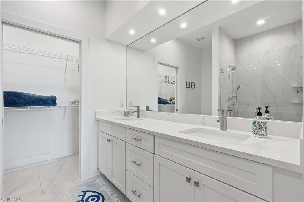 Double vanity featuring white shaker cabinetry, undermount sinks, and light-colored countertops