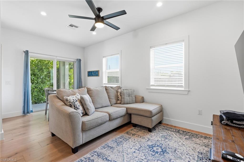 Living area featuring wood-finish flooring, recessed lighting, and a modern ceiling fan
