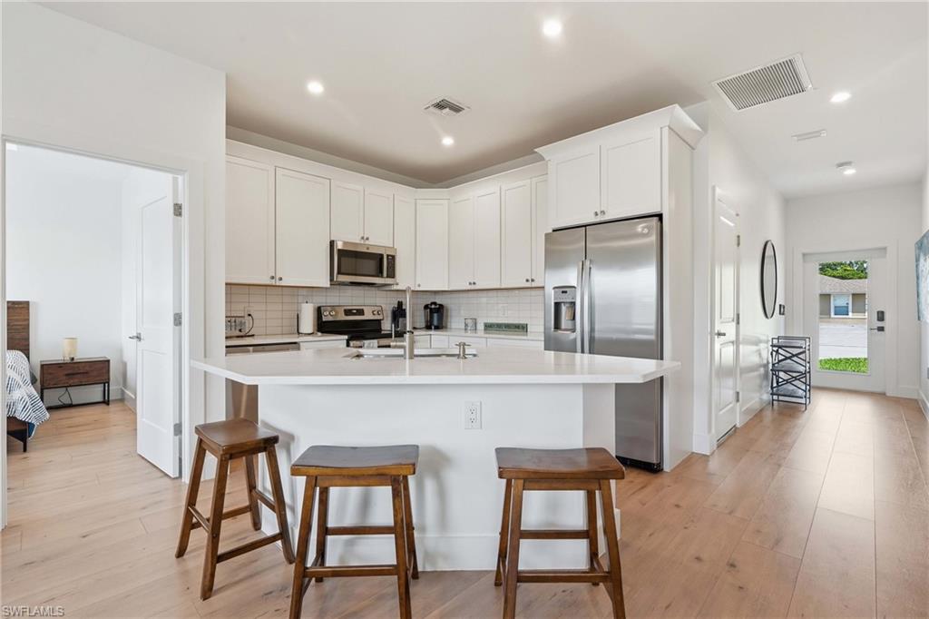 Modern kitchen with white cabinetry and stainless steel appliances