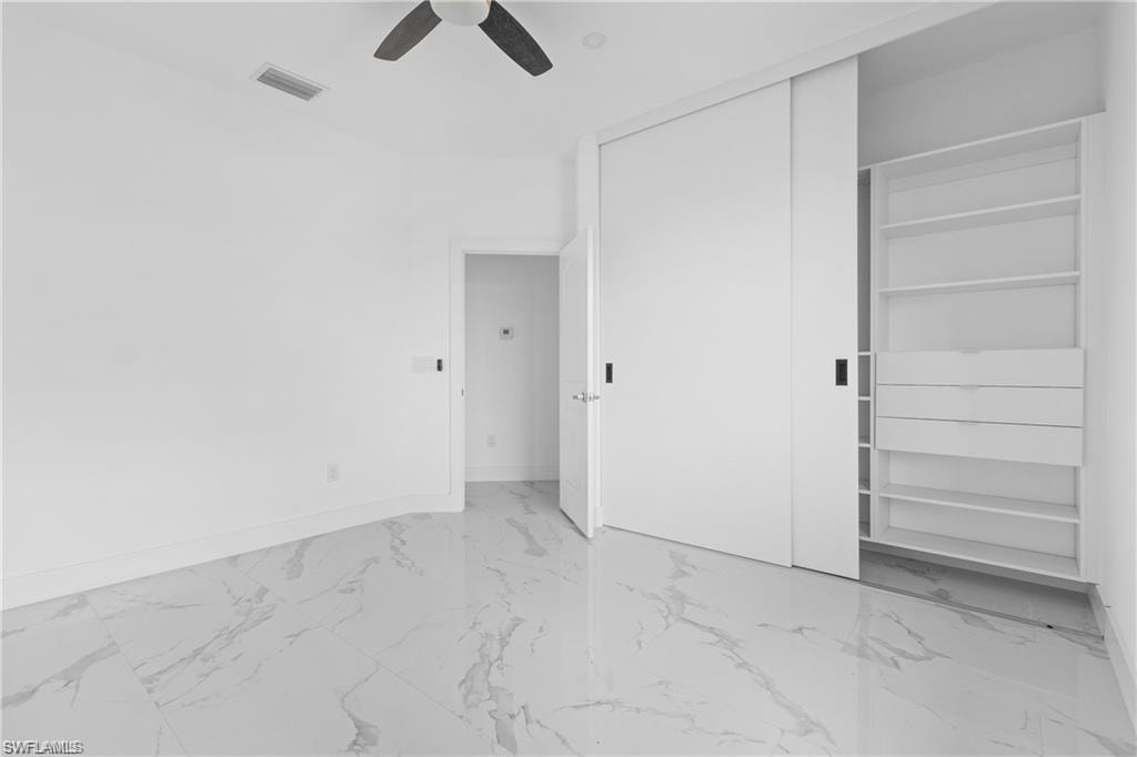 Minimalist room featuring white walls and marble-look tile flooring