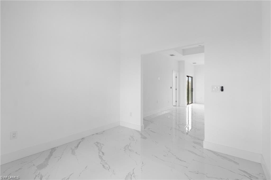 Spacious interior featuring a large entryway, white-painted walls, and polished tile flooring