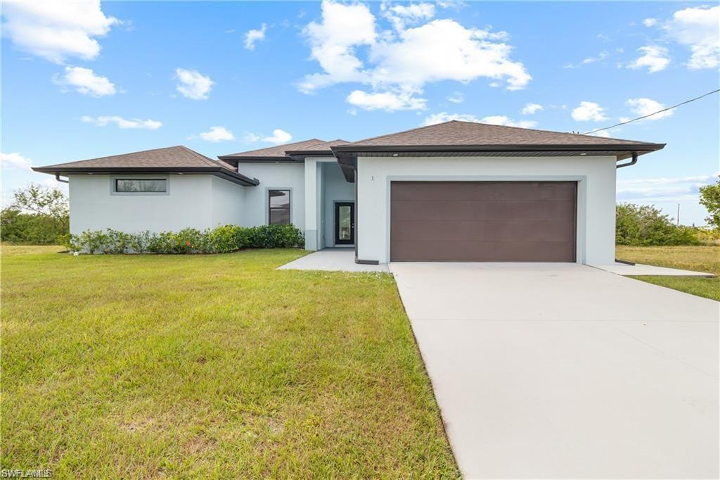 Contemporary single-story residence featuring a two-car garage, light stucco exterior, and a dark brown garage door
