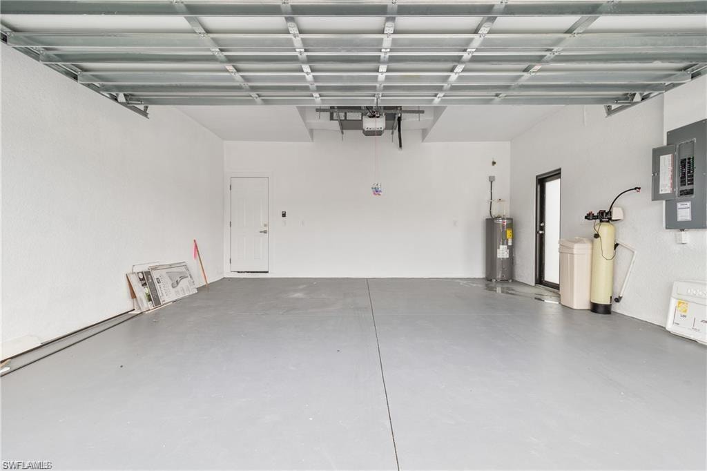 Spacious garage featuring a durable epoxy-coated floor, automatic garage door opener, and a water heater