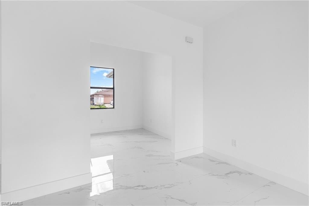 Bright interior space featuring white walls and large format tile flooring