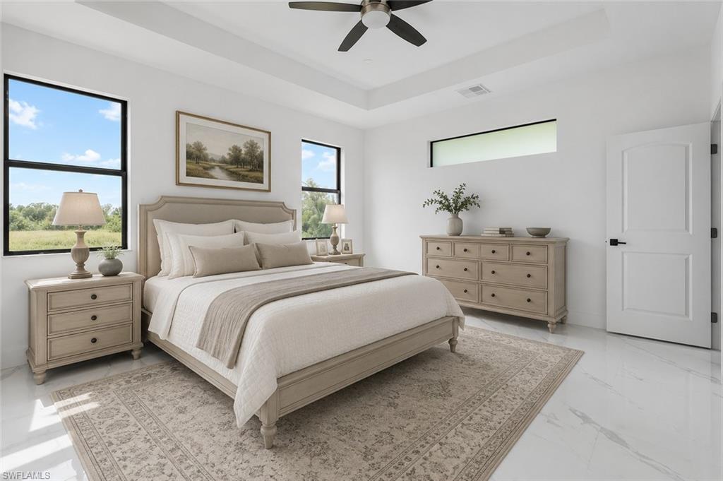 Spacious room featuring tray ceilings, white walls, and light-toned flooring