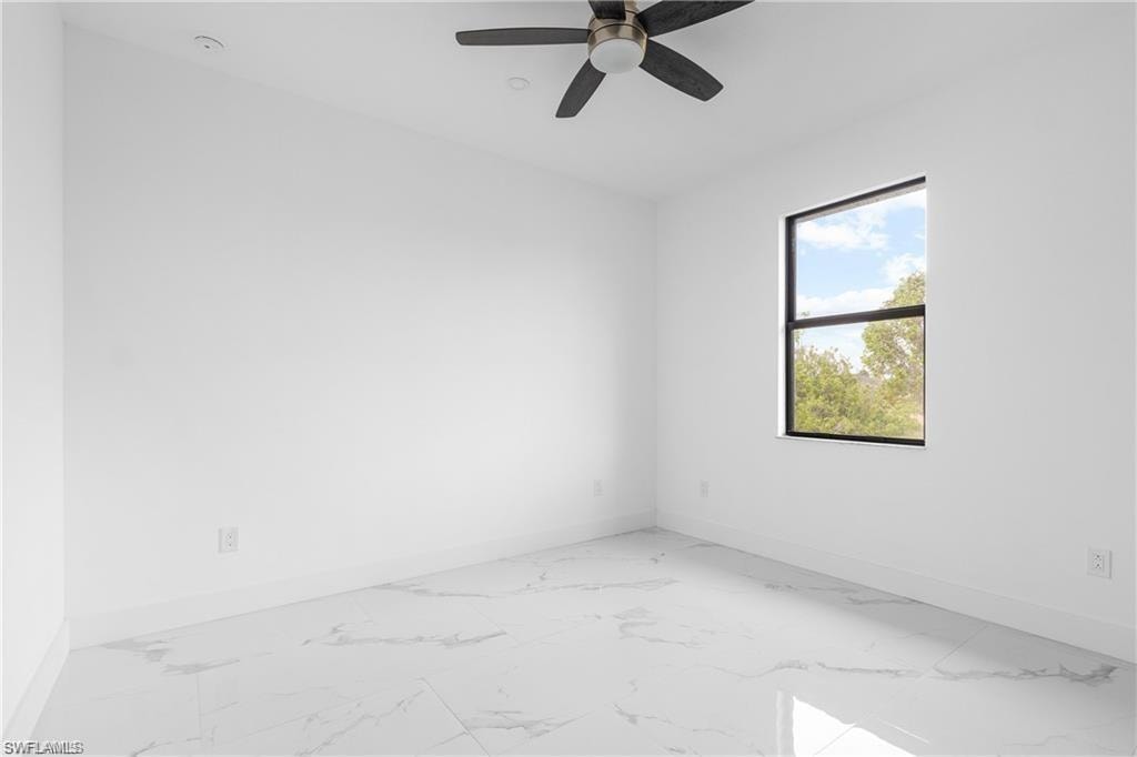 Spacious room featuring large format tile flooring, a modern ceiling fan, recessed lighting, and a prominent window with dark framing