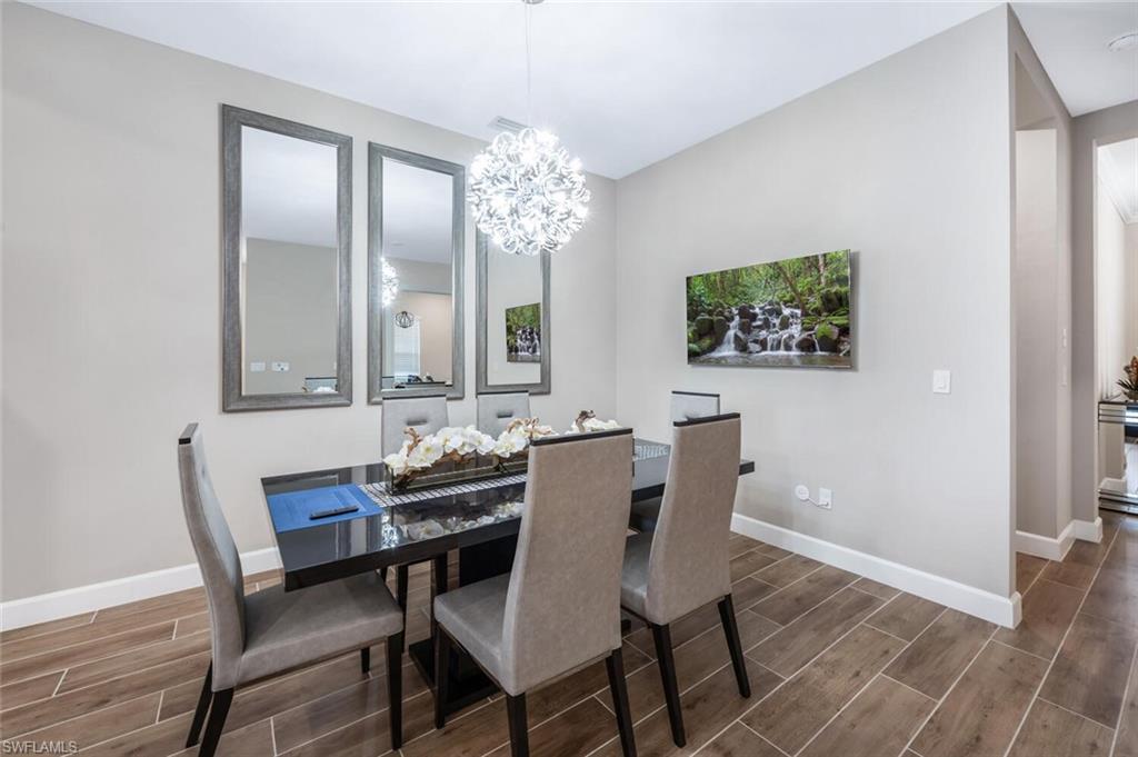 Dining area featuring wood-finish tile flooring and a contemporary chandelier