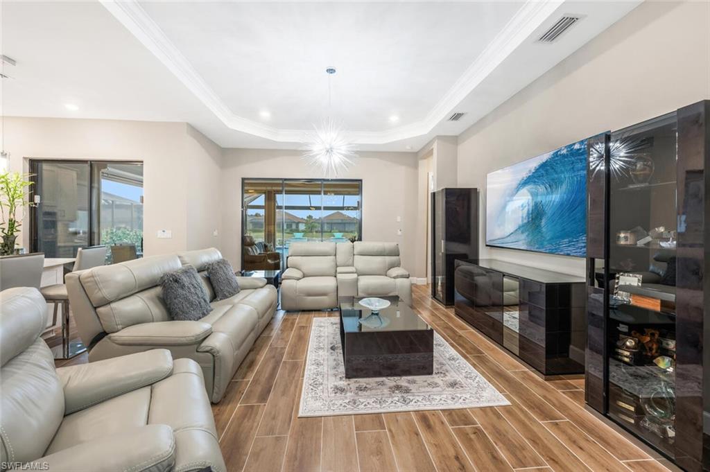 Open concept living area featuring wood-finish flooring and a tray ceiling