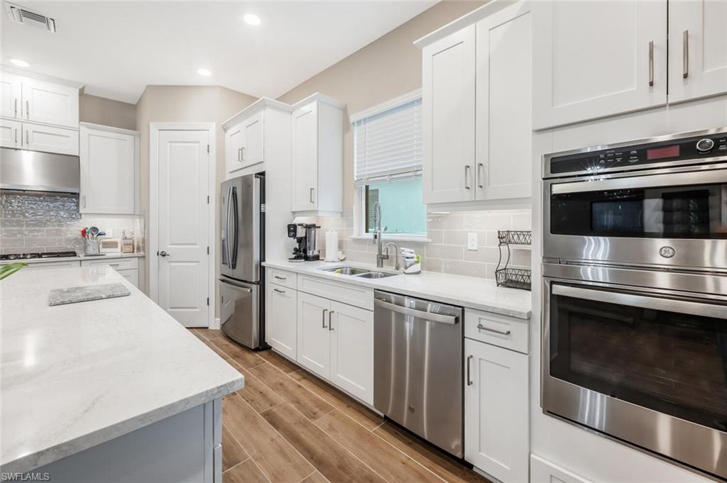 Modern kitchen featuring a light gray kitchen island with a white countertop