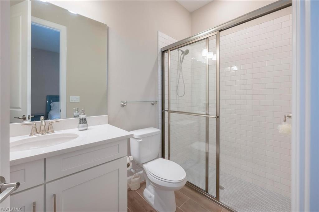 Bathroom featuring a white vanity with a single basin sink, white countertop, and brushed nickel faucet