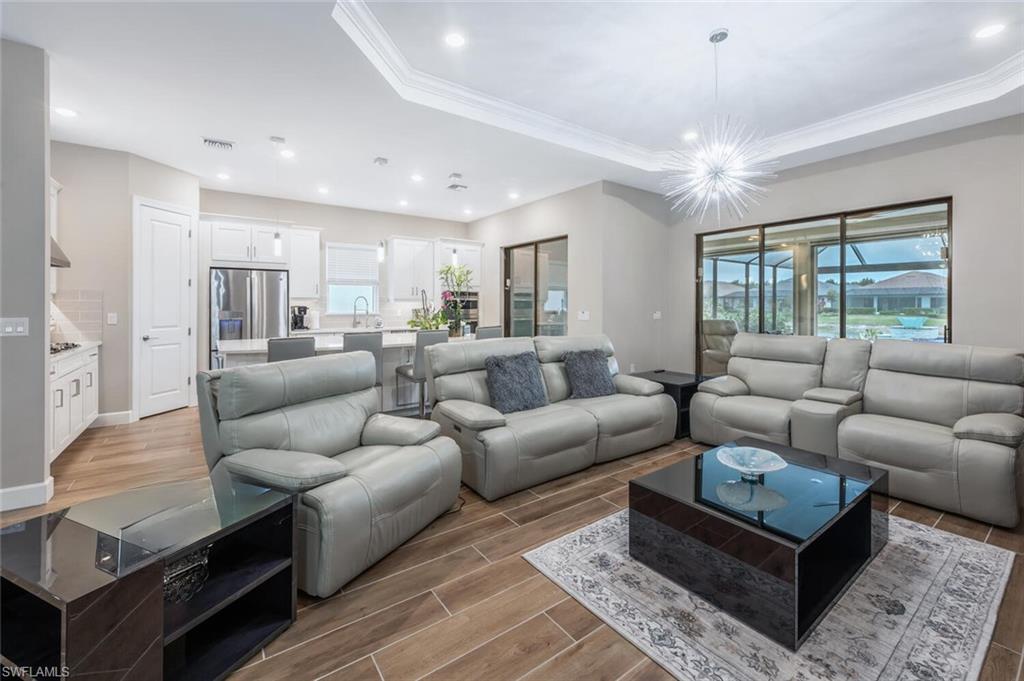 Open-concept living space featuring wood-finish tile flooring, recessed lighting, and a contemporary ceiling fixture