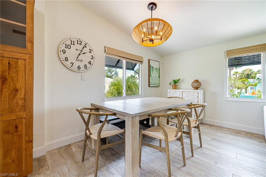 Dining area featuring wood-finish flooring, a vaulted ceiling, and recessed lighting