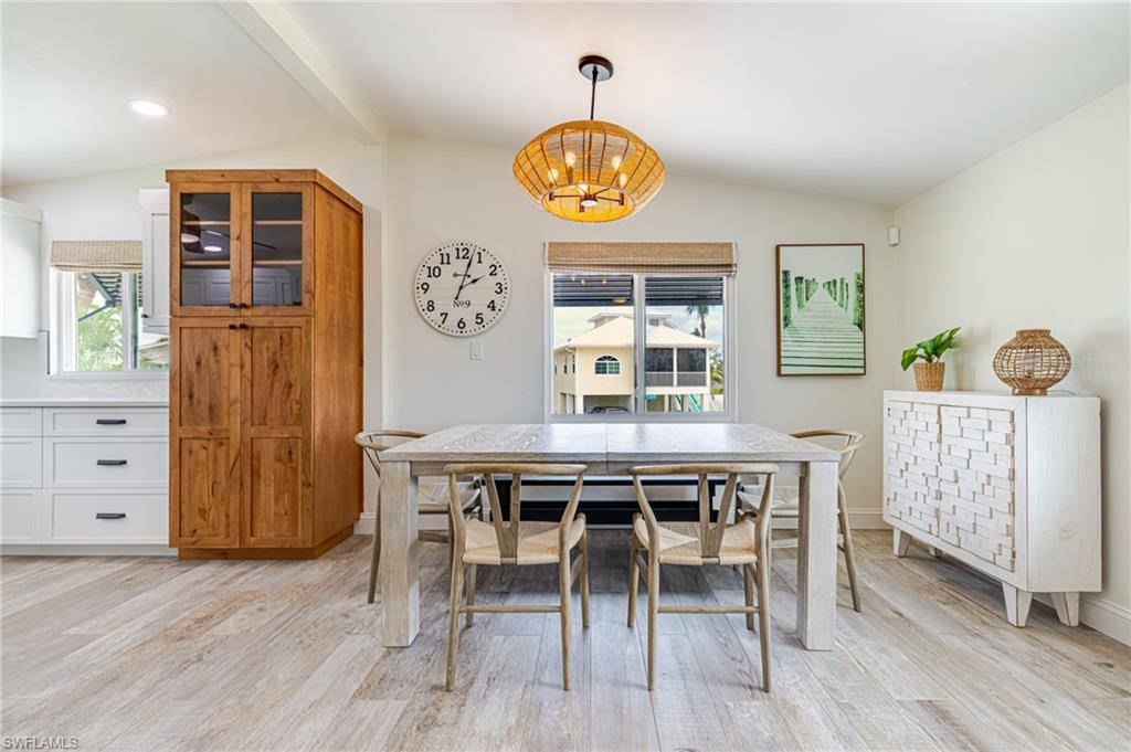 Dining area with vaulted ceilings and light wood-finish flooring