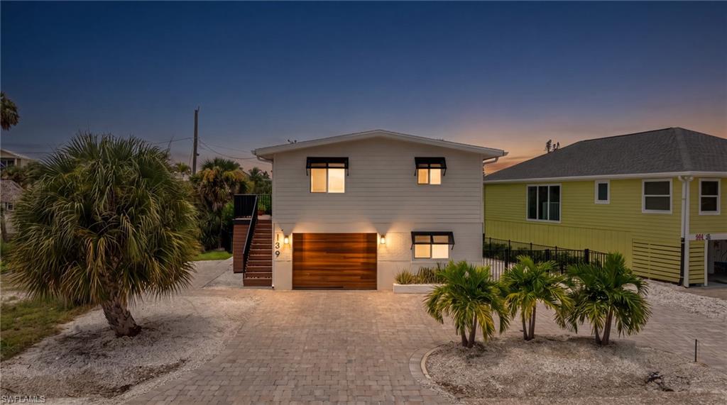 Contemporary architecture with white horizontal siding and a wood-finish garage door