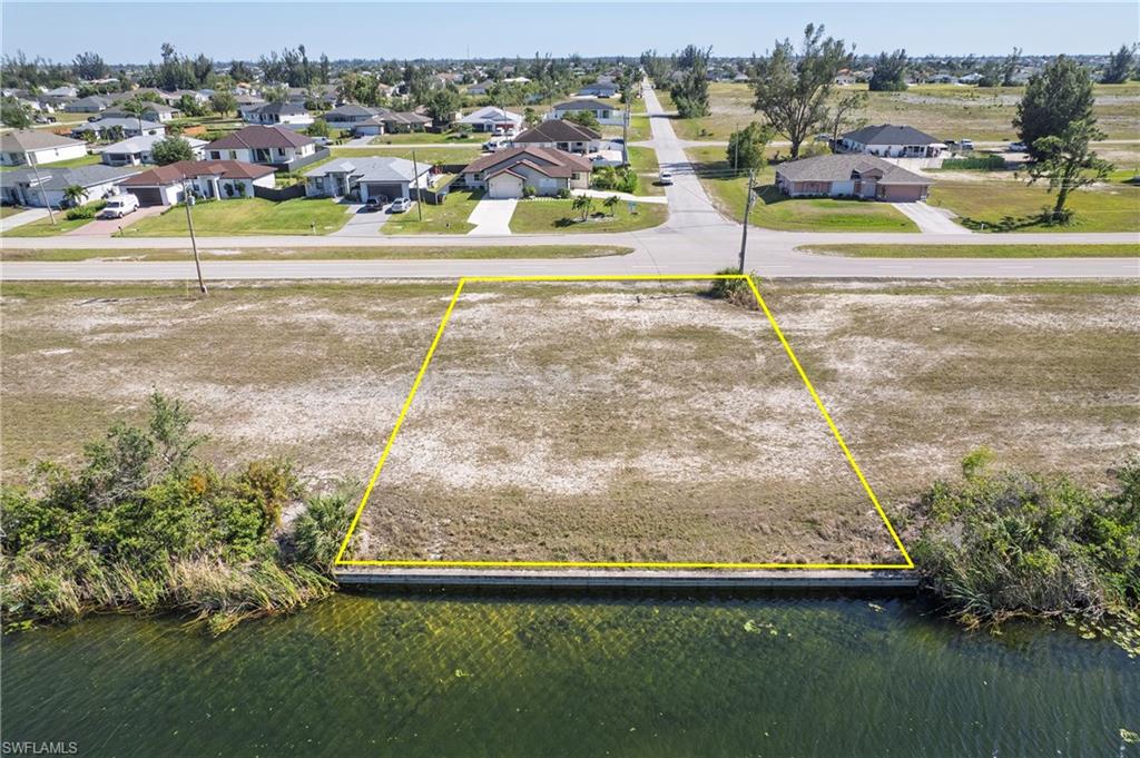 Waterfront lot featuring a concrete seawall and direct canal access