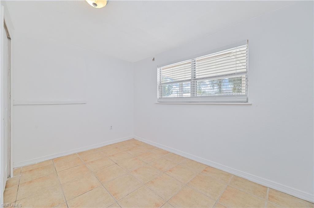 Empty room with baseboards and light tile patterned floors