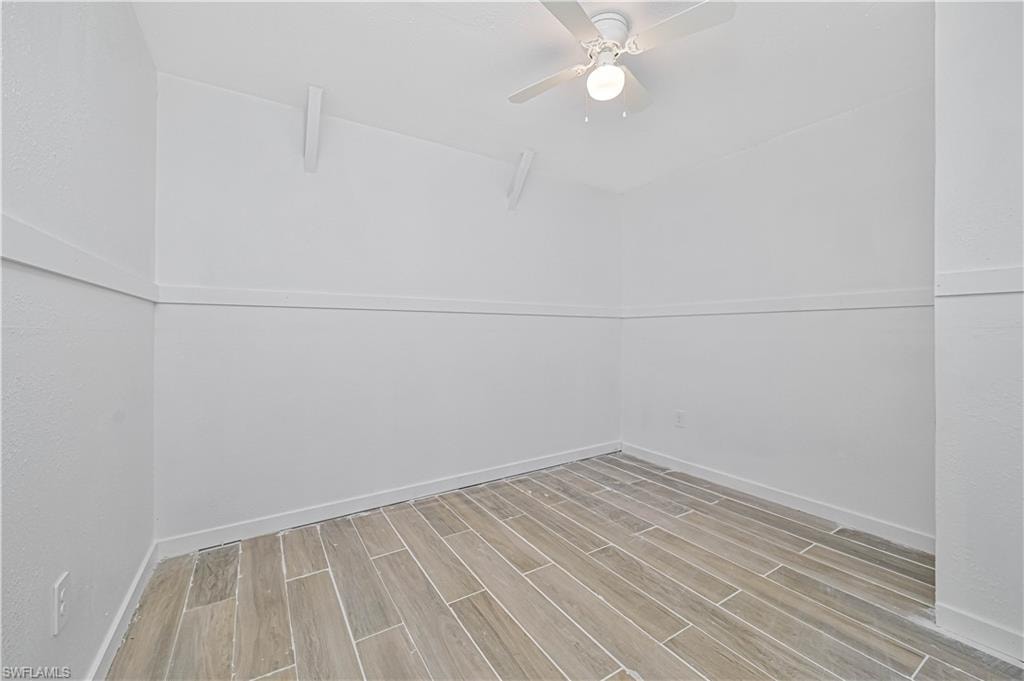 Unfurnished room featuring wood tiled floors and a ceiling fan