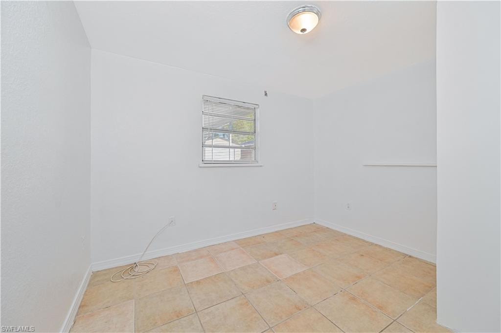 Unfurnished room with baseboards and light tile patterned floors