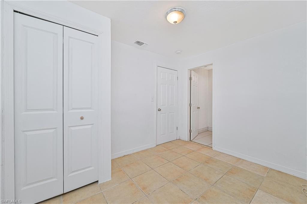 Unfurnished bedroom featuring a closet and light tile patterned floors
