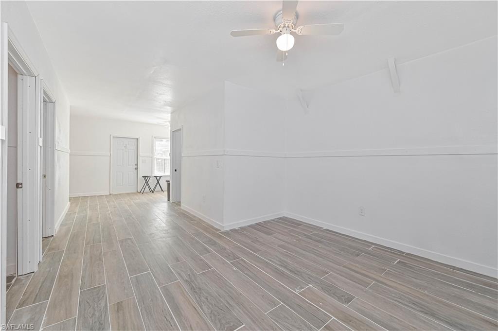 Empty room with wood tiled floors and ceiling fan