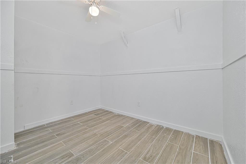 Spare room featuring wood tiled floors and baseboards