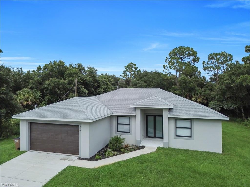Modern single-story residence with a gray shingle roof and light gray stucco exterior
