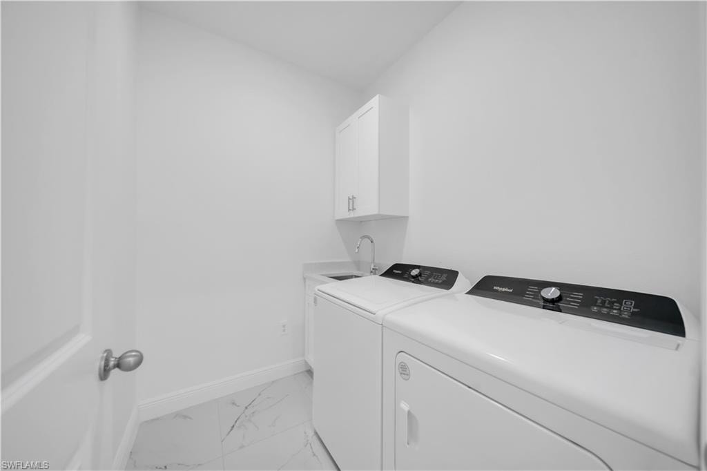 Dedicated utility room featuring a built-in sink, white cabinetry, and a white countertop